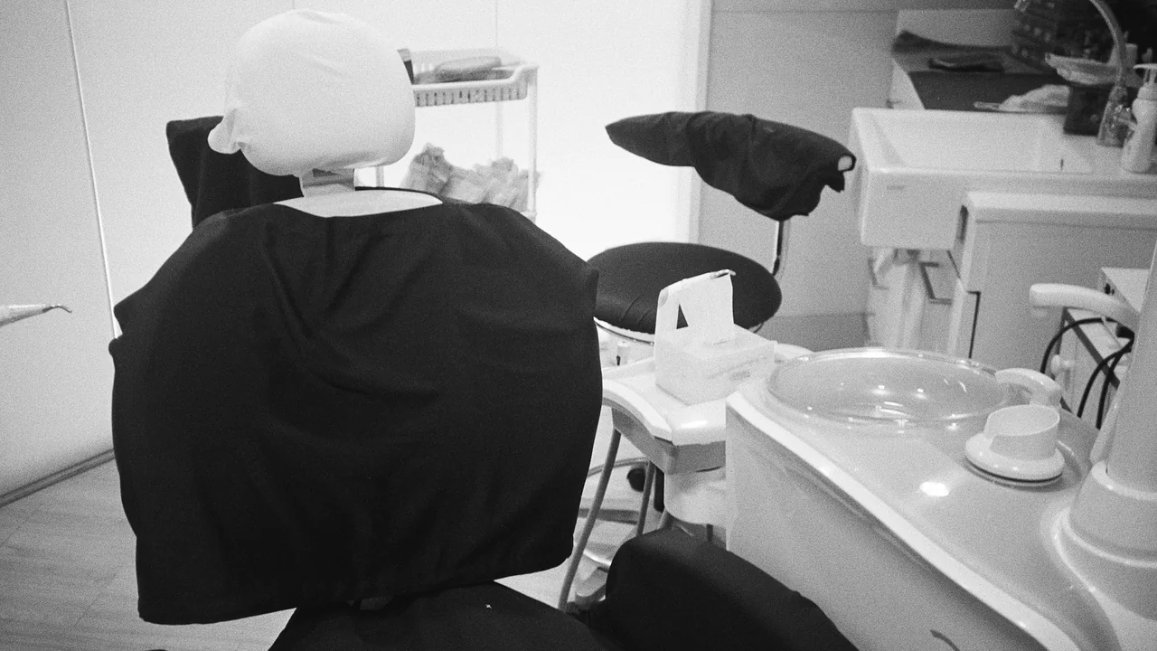 An empty dental chair with examination equipment