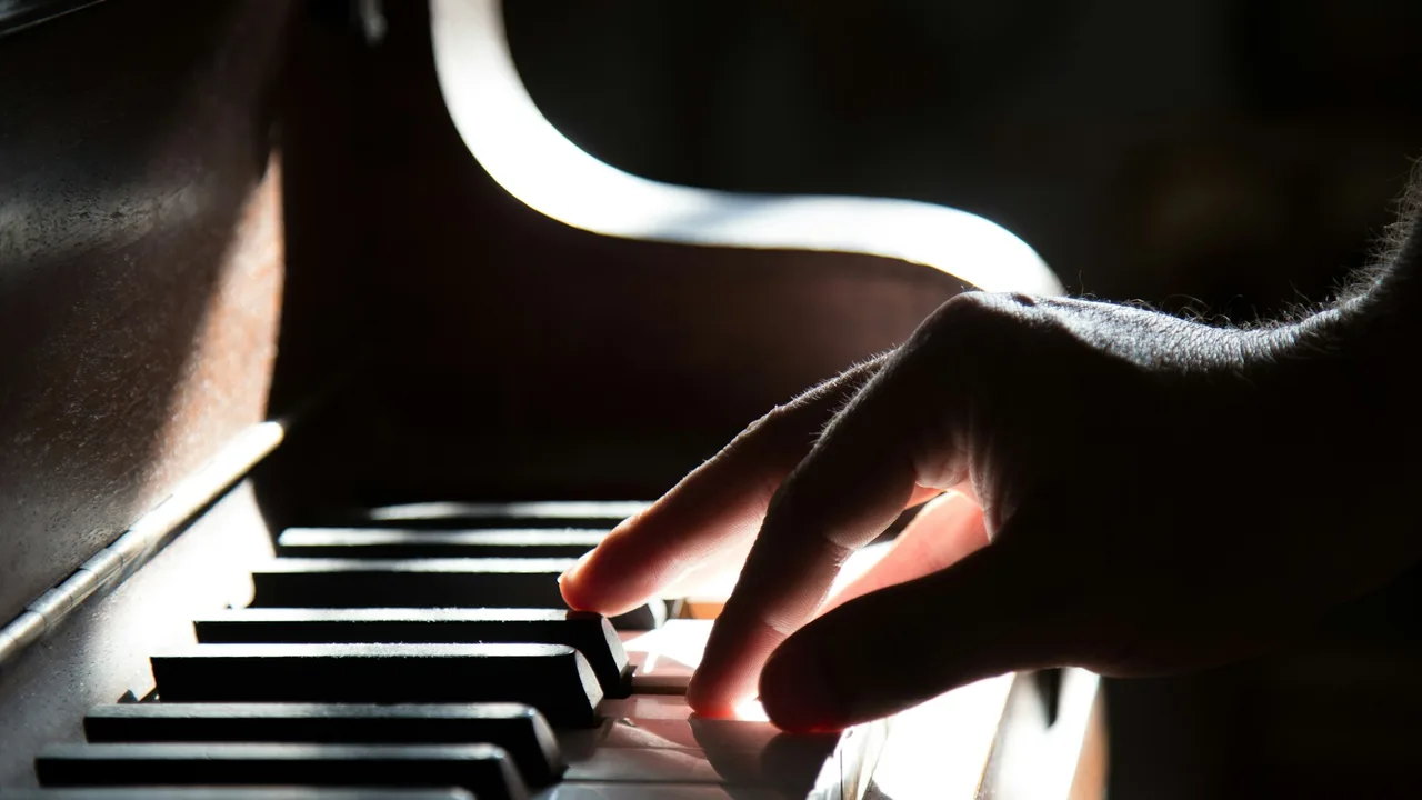 Hands playing piano keys