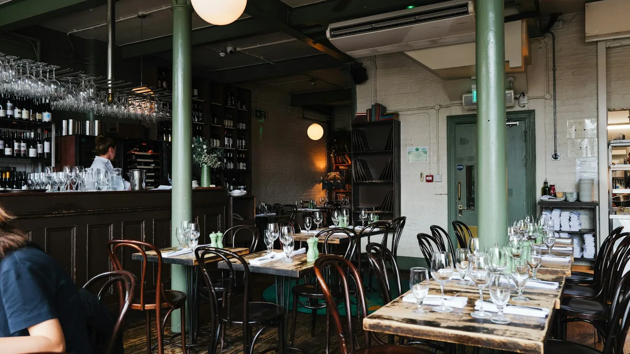 Set restaurant tables beside a bar in a dining room