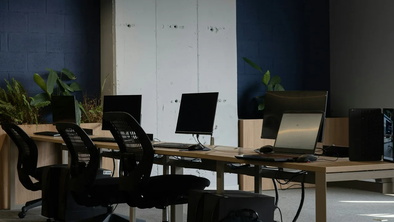 Shared office tables with computers and chairs